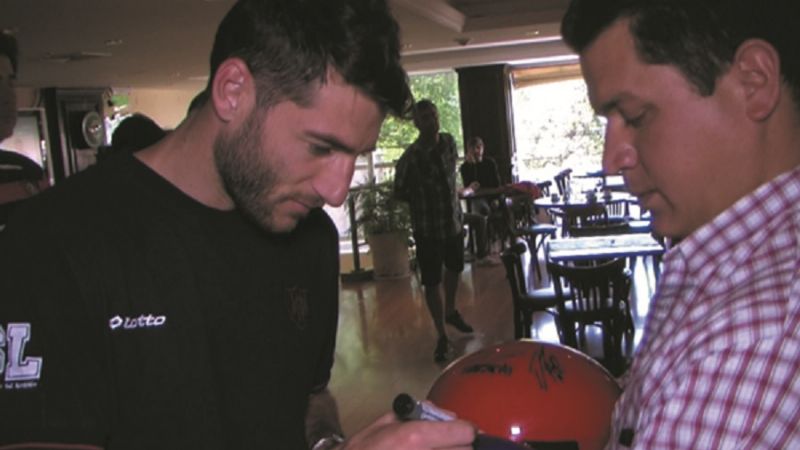 El DT campeón, periodista y jugadores firmaron cascos