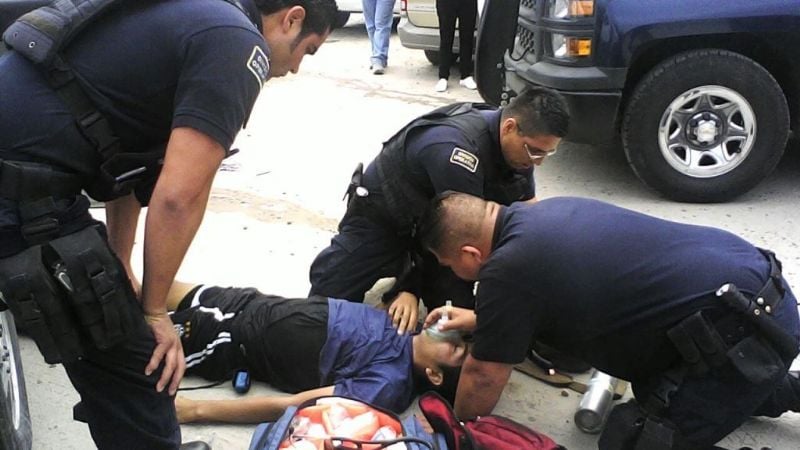 Policías asisten a un joven que estaba tirado en la calle