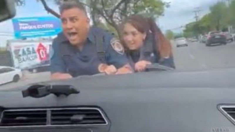 Manejó 100 metros con dos policías en el capot