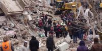 Equipos de rescate buscan supervivientes bajo los escombros de un edificio dañado por un terremoto en Azaz, Siria.